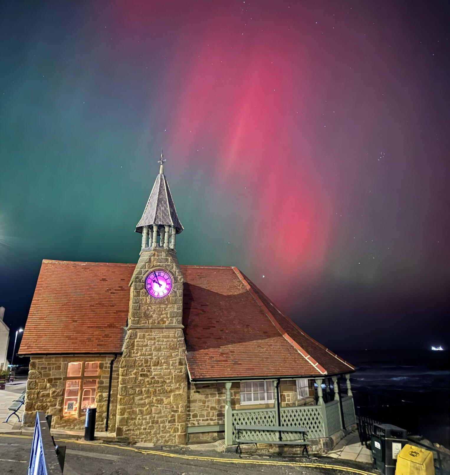 A photo of the Watch House from the south during the Northern Lights Aurora in red and green